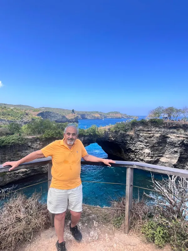 Guest standing at the natural sea arch of Broken Beach, Nusa Penida