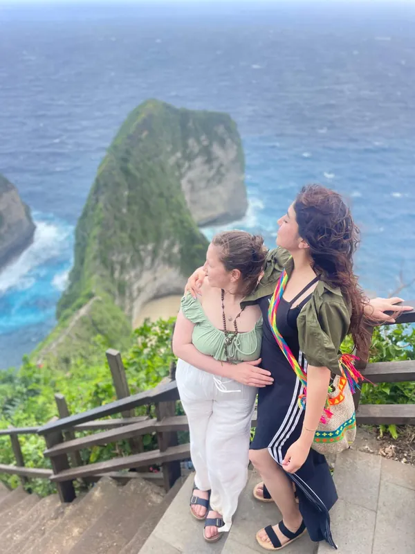 Two friends at the Kelingking Beach cliff edge on a private tour