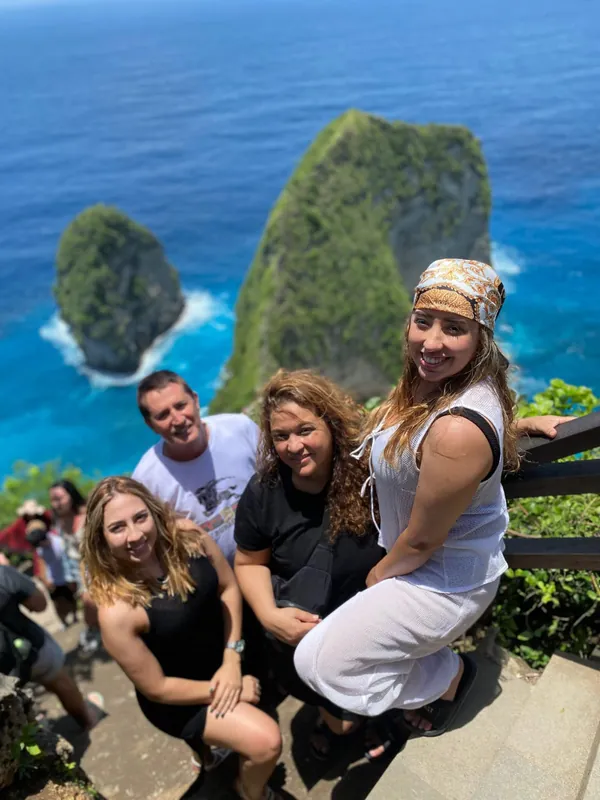 Group of friends smiling at the Kelingking cliff viewpoint